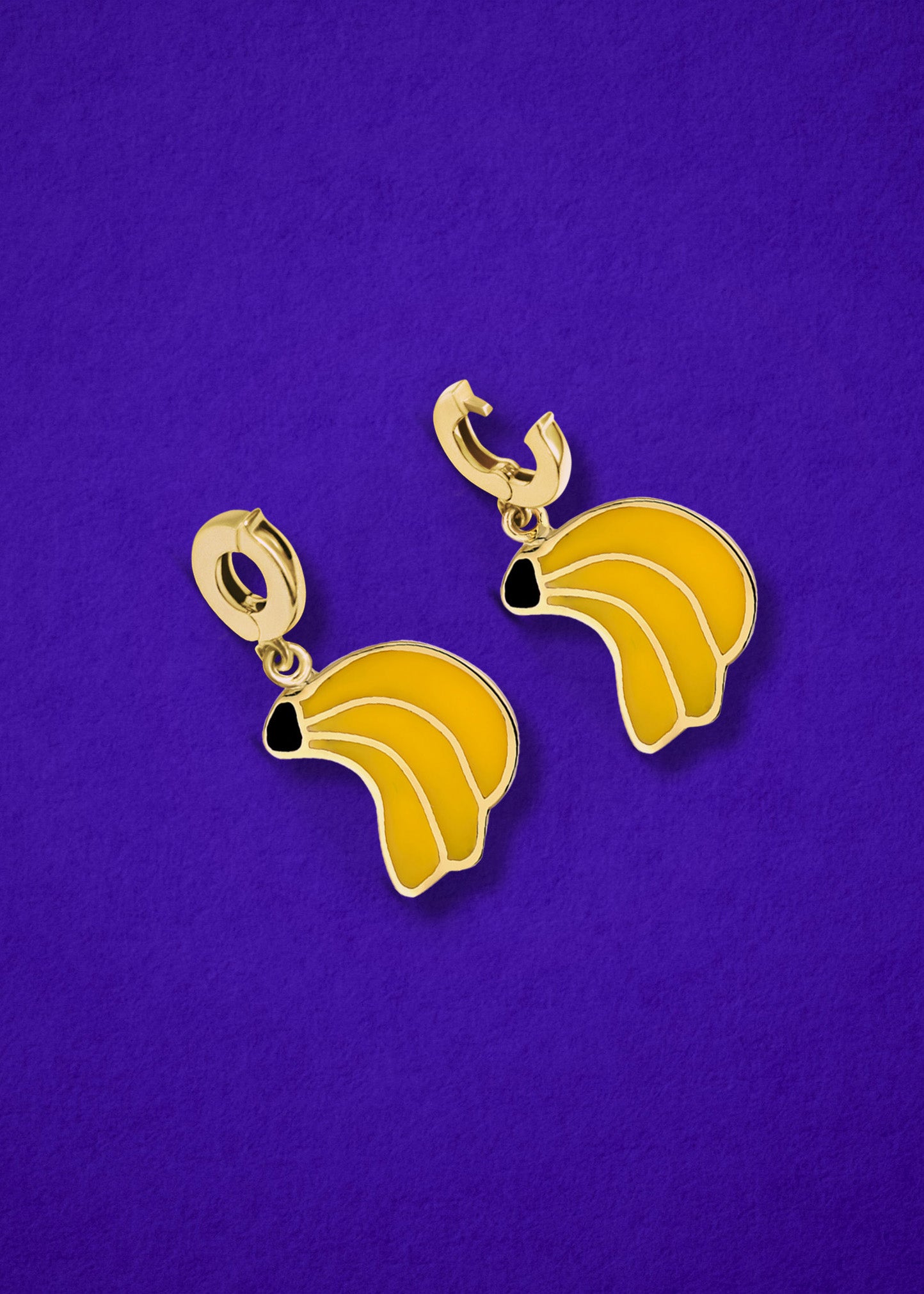 Banana Bliss Charm showing both open and closed views of the 14K solid gold clip, with vibrant yellow enamel, displayed on a purple background.