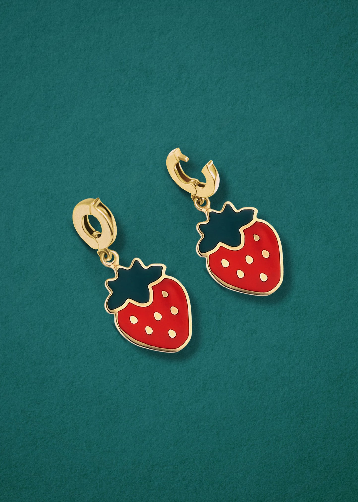 Sweet Strawberry Charm showing both open and closed views of the 14K solid gold clip, with red enamel, displayed on a tale background.